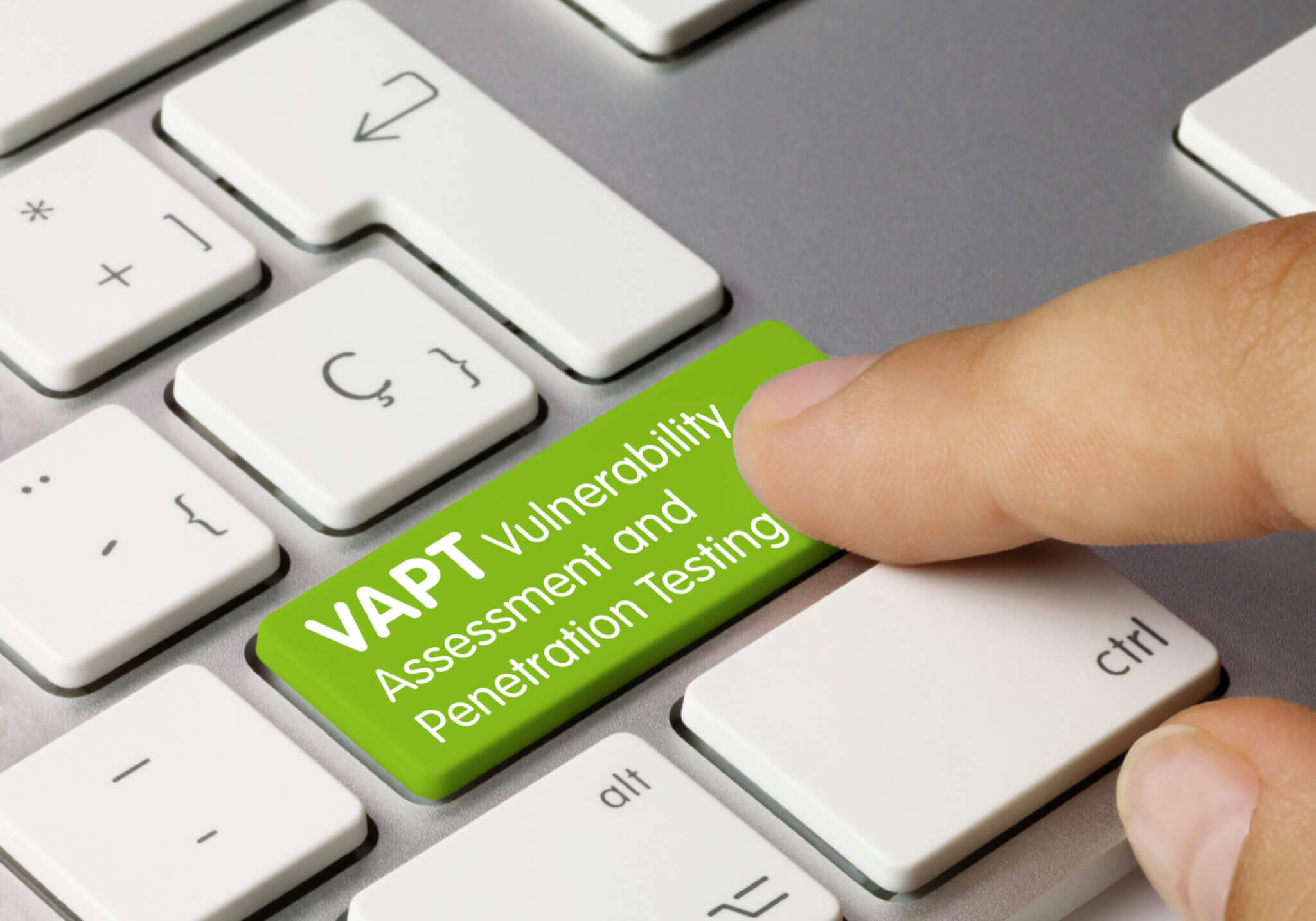 VAPT Vulnerability Assessment and Penetration Testing Written on Green Key of Metallic Keyboard. Finger pressing key.